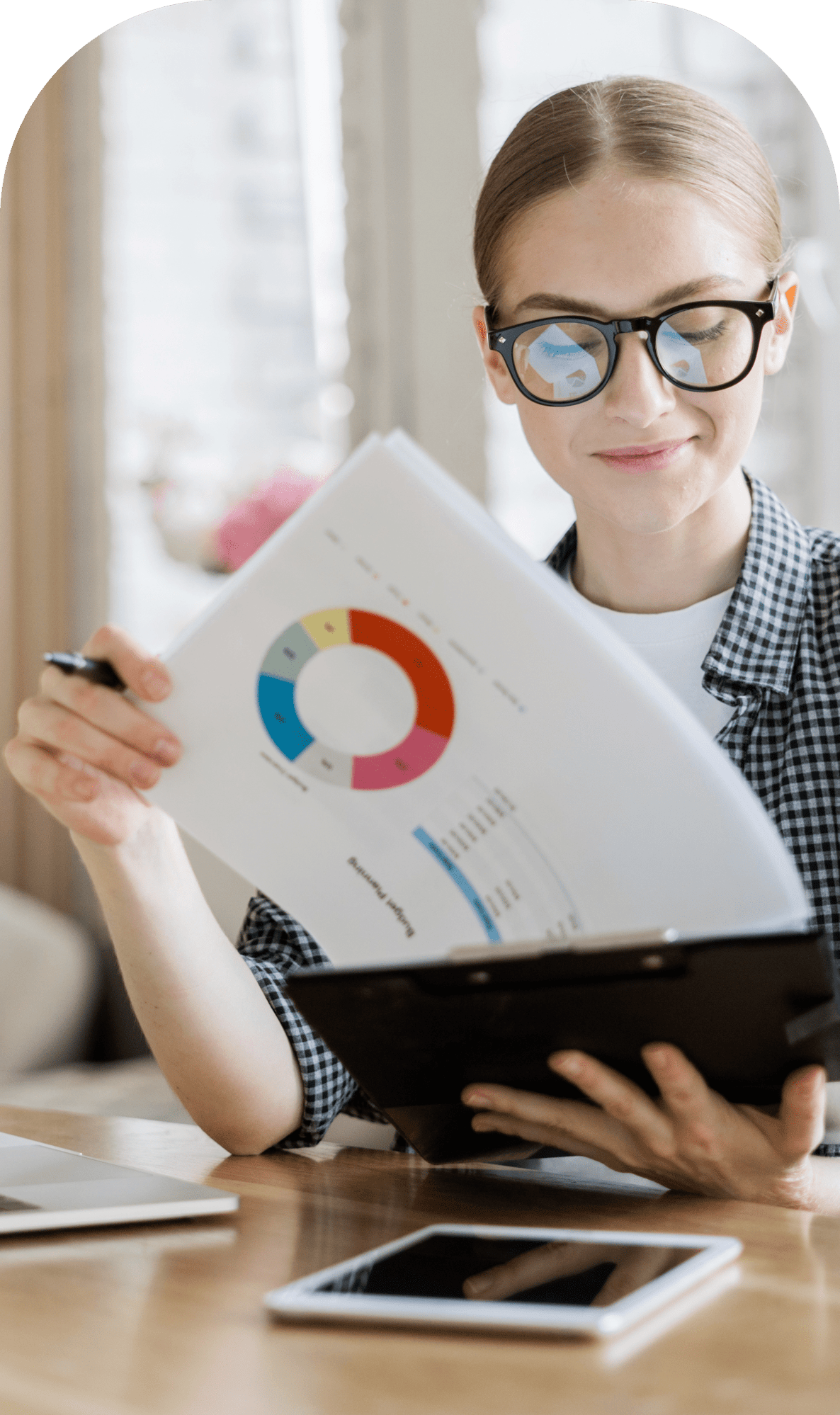 Woman looking at clipboard with graphs and data.