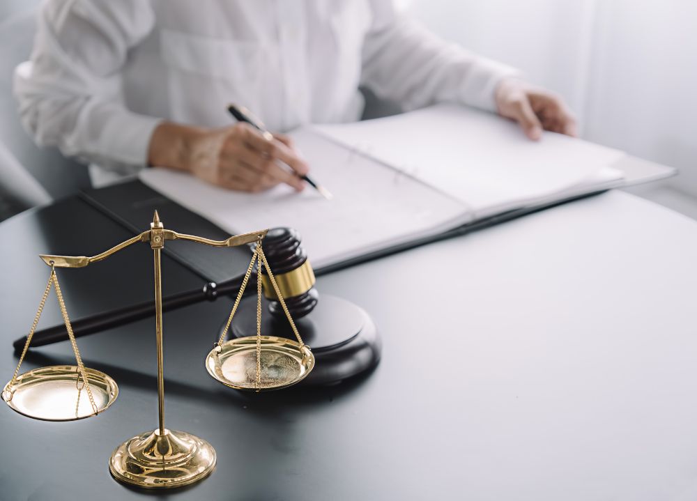 Lawyer sitting at desk writing on notepad